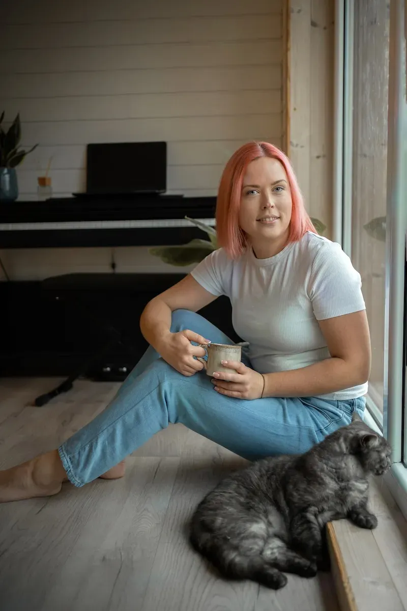 Psichologė Iveta Litvinienė namų aplinkoje su kate ir kava